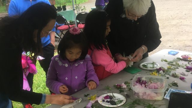 Kids making bracelets with flowers and ferns